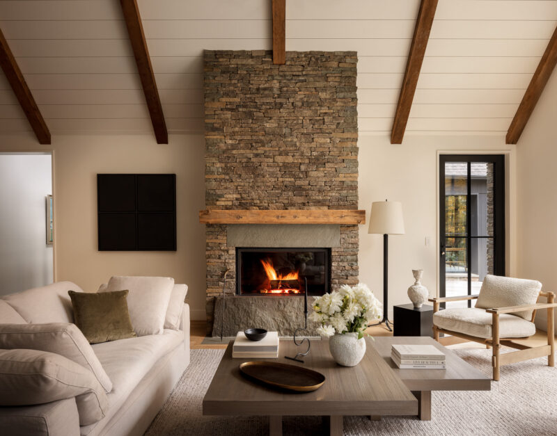 Interior design of a living room with a tall stone fireplace located in the Poconos.