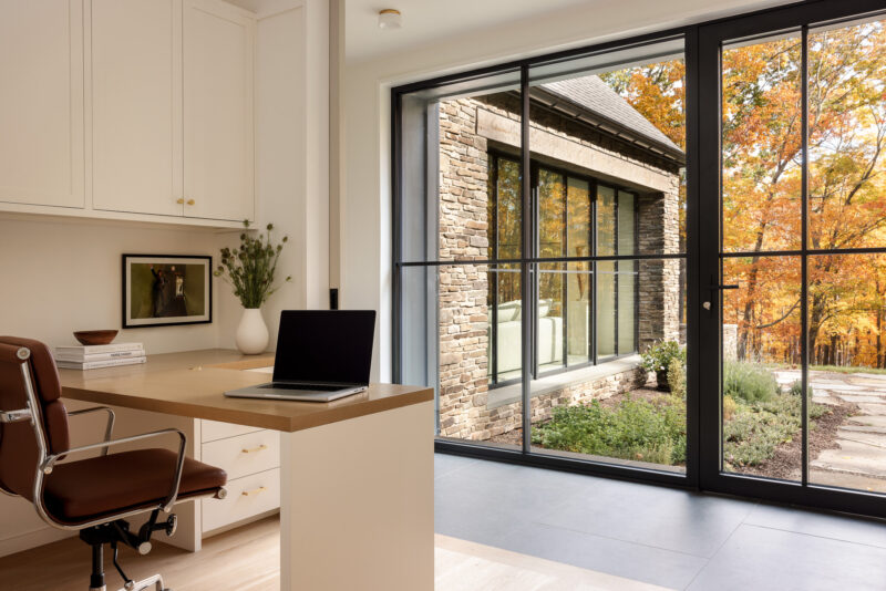 Interior design of a modern office with fall leaves outside located in the Poconos.