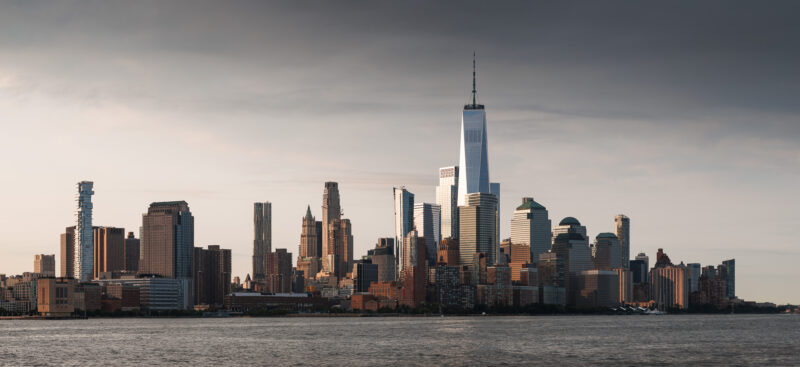 Lower Manhattan cityscape during sunrise with dramatic clouds