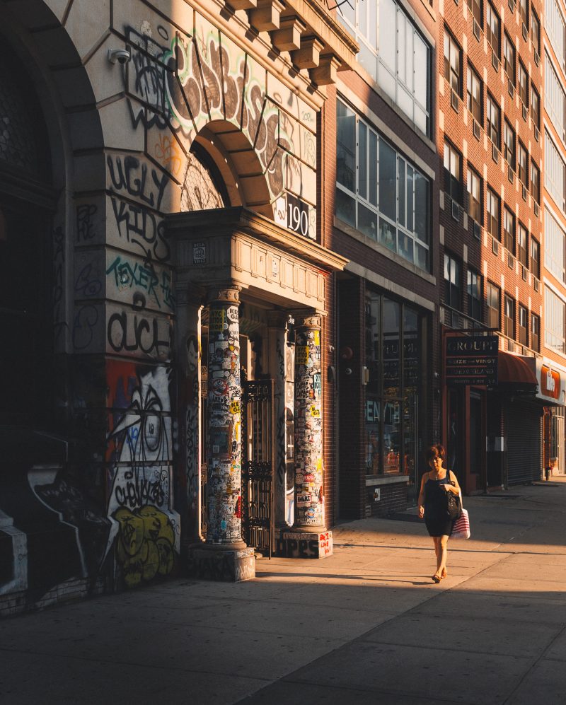 Woman walking in China Town, NYC illuminated by light